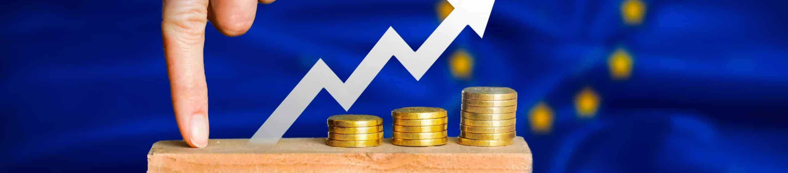 Stacks of coins in front of positive trend line